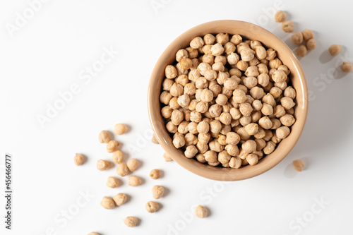 dry chickpeas, in a ceramic dish on a white table, top view, close-up