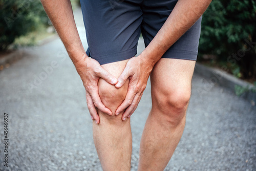 Man having having clicking or grinding sound of the kneecap due to runner's knee photo