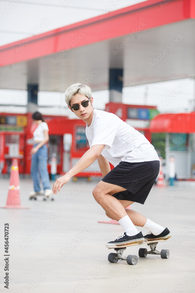 asian young man wear sunglasses playing skateboard on street city.  skateboarding outdoor sports. extreme sports concept. Stock-Foto | Adobe  Stock