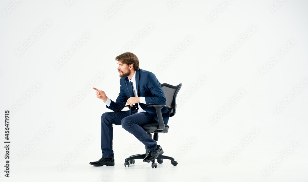 bearded man in a suit sitting in an office chair work light background bearded man in a suit sitting in an office chair work light background