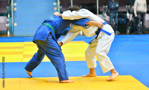 Two Boys judoka in kimono compete on the tatami 