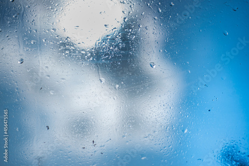 raindrops on glass, blue background with water drops