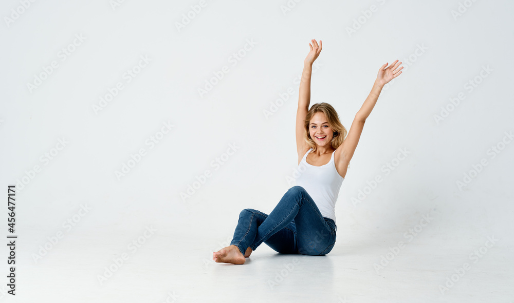cheerful blonde sitting on the floor emotions posing light background cheerful blonde sitting on the floor emotions posing light background