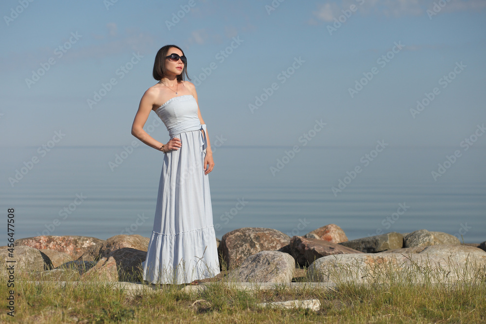 young woman in summer clothes by the sea