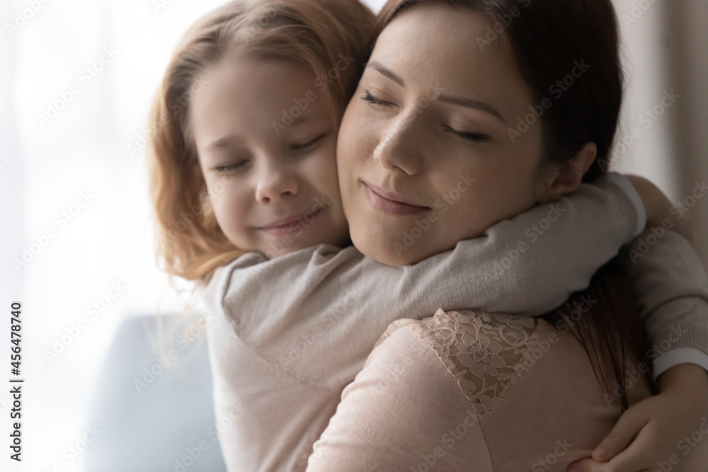 Head shot sincere loving little kid girl cuddling young mother, missing after long separation time. Happy positive two female generations family showing sweet tender feelings, candid relations concept Head shot sincere loving little kid girl cuddling young mother, missing after long separation time. Happy positive two female generations family showing sweet tender feelings, candid relations concept
