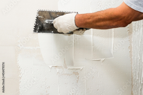 Application of plaster on the wall with a comb.