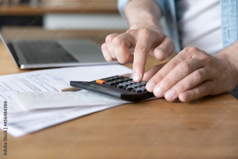 Close up on table lie document, invoices, receipts, utility bills, unrecognizable Caucasian male hands costs personal incomes and expenses using calculator, pay for loan, manage family budget concept Close up on table lie document, invoices, receipts, utility bills, unrecognizable Caucasian male hands costs personal incomes and expenses using calculator, pay for loan, manage family budget concept