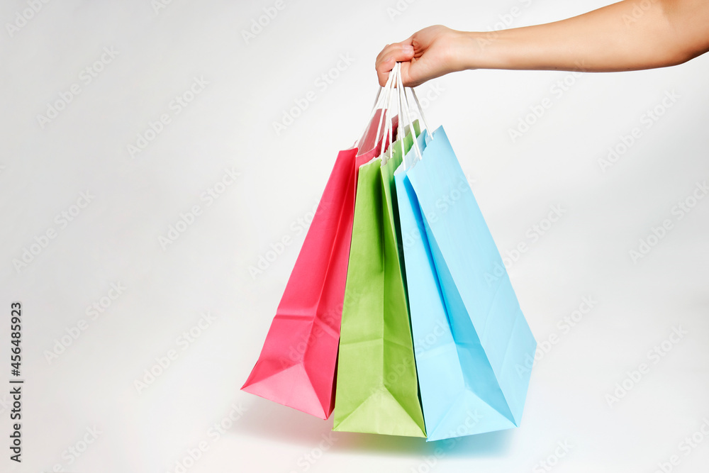 Woman hand with shopping bags on white background