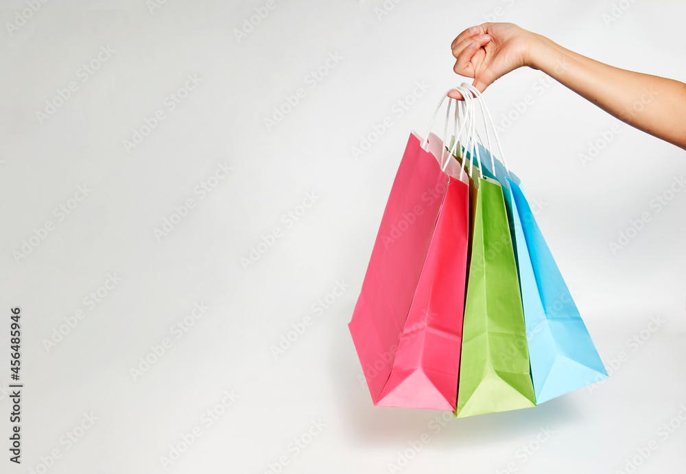 Woman hand with shopping bags on white background