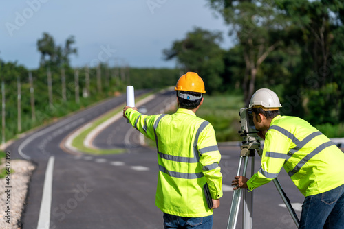 Teamwork of surveyor engineers worker making measuring with theodolite on road works. survey engineer at road construction site, Surveyor equipment.