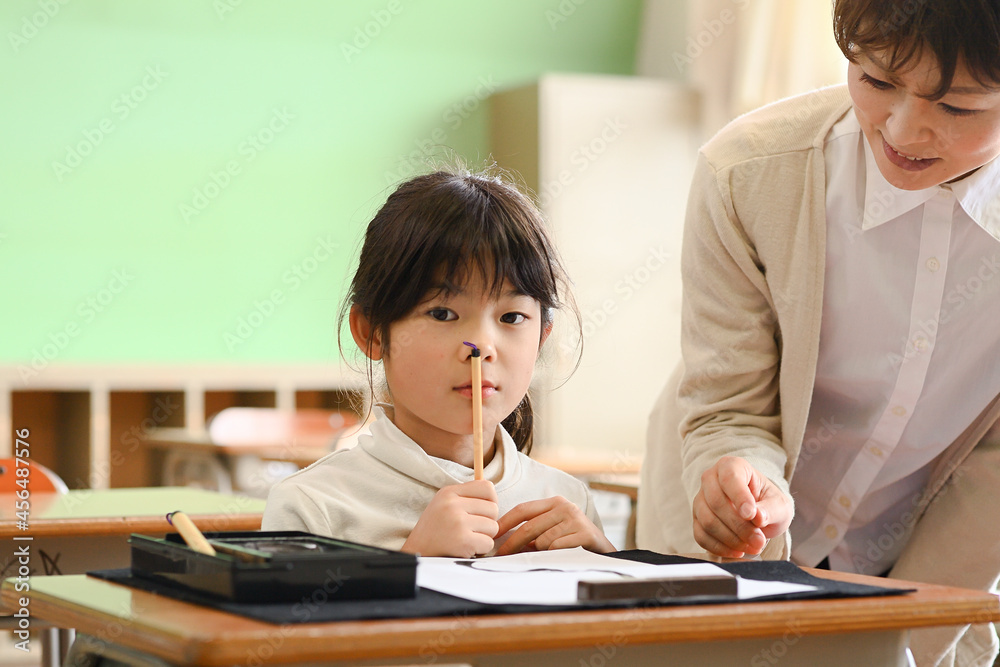教室で習字の勉強 小学生の女の子 寅年の筆書き 教室で習字の勉強 小学生の女の子 寅年の筆書き