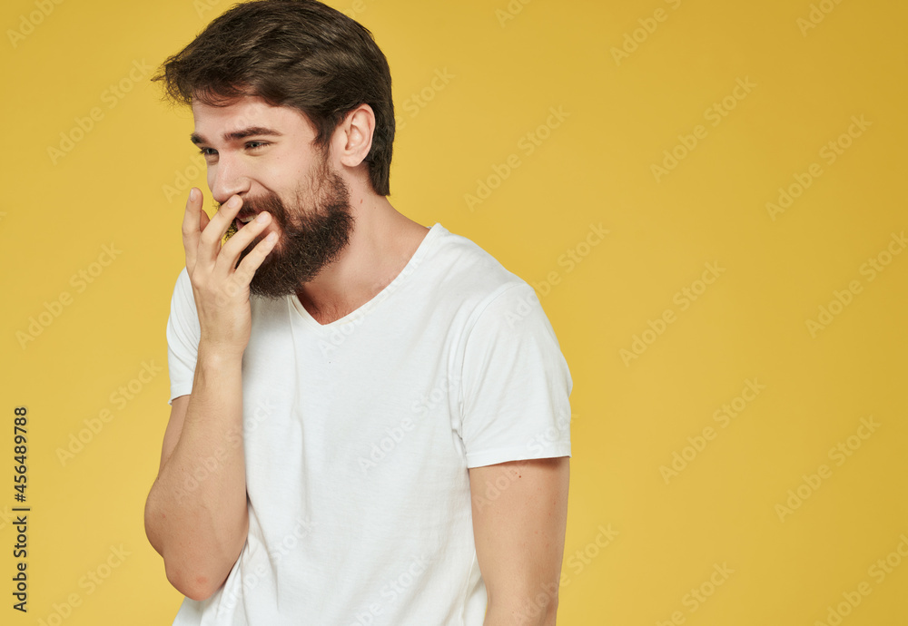 emotional man in a white t-shirt hand gestures anger yellow background emotional man in a white t-shirt hand gestures anger yellow background