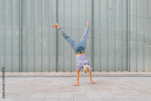 Foto Young caucasian athletic gymnast woman outdoors soing cartwheel sportive and dyn