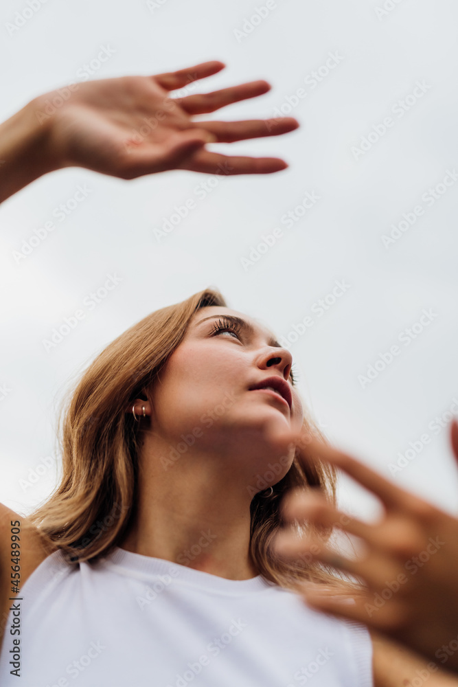 Fototapeta premium Young caucasian woman dancing outdoor gesturing with hands feeling free