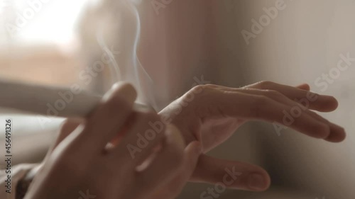 Alternative therapist applying moxibustion a traditional chinese medicine method. Doctor healing young patient with traditional asian medicine. Moxa stick alone. Extreme close up. Moxibustion.