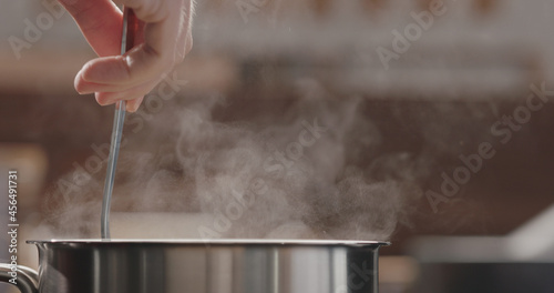 Fotografia penne pasta stir in saucepan with boiling water