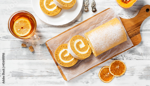 Pumpkin Cake Roll with Cream Cheese Filling. Autumn Baking. White wooden background, top view