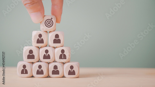hand holding dart icon on wood block stack , strategy business method to target, brainstorming manpower to success, teamwork and business concept