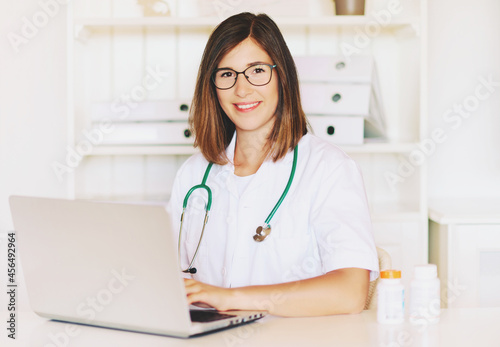 Interior portrait of young female doctor working in the office