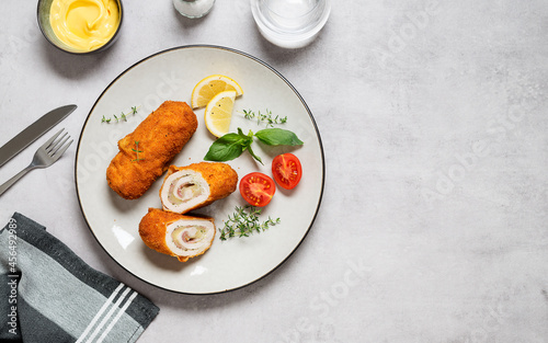 French traditional cuisine crispy, creamy chicken cordon bleu on gray background. top view. space for text photo