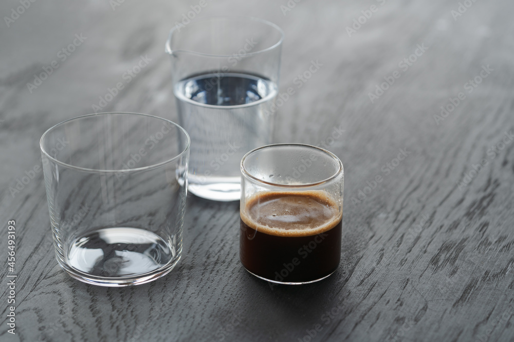 Ingredients for espresso tonic with clear ice cube in tumbler glass on oak wood table with copy space Ingredients for espresso tonic with clear ice cube in tumbler glass on oak wood table with copy space