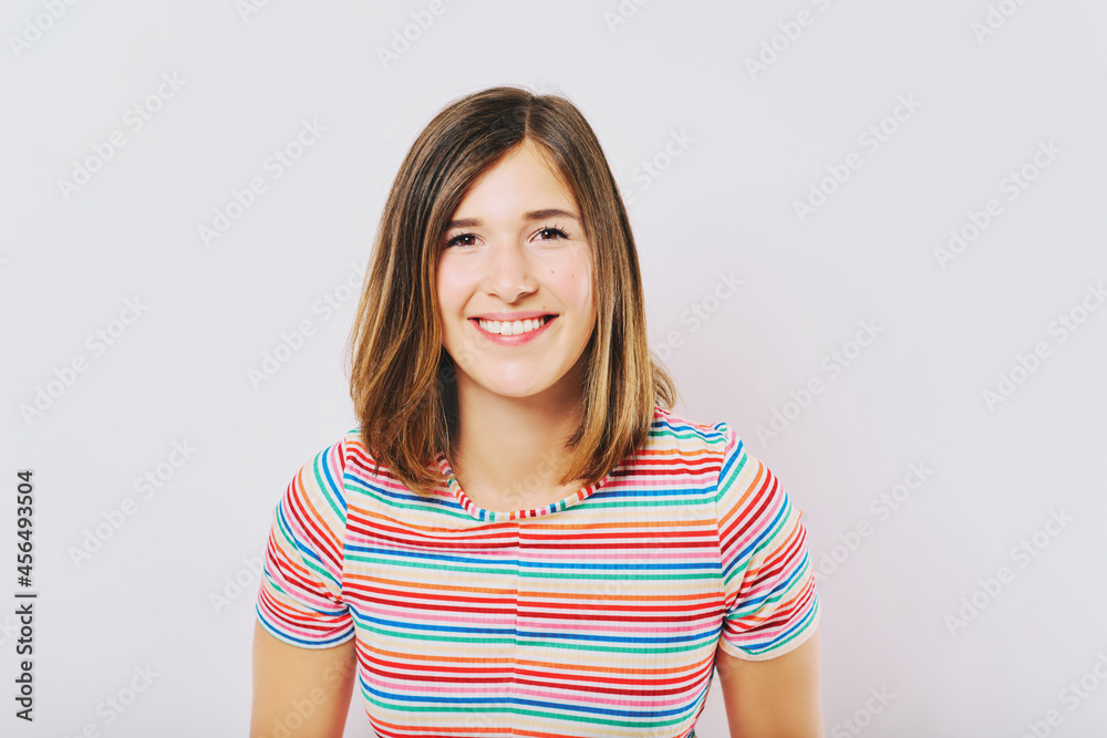 Studio close up portrait of pretty young woman with brown hair, wearing colorful rainbow top Studio close up portrait of pretty young woman with brown hair, wearing colorful rainbow top