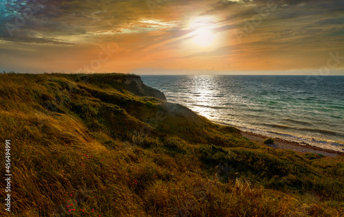 Photo of the sea evening landscape. Evening sea, sunset, dunes and hills, beautiful coast and waves.