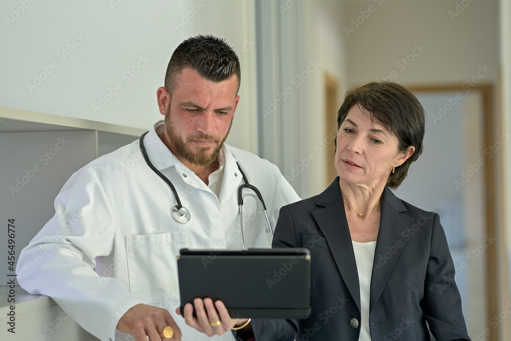 Discussion between a doctor and his medical secretary in the office Discussion between a doctor and his medical secretary in the office