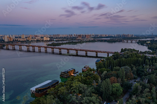 Evening Kiev from a bird's eye view. Architectural monuments. The light of lanterns and evening lights. City on the Dnieper. White buildings. Sunset.
