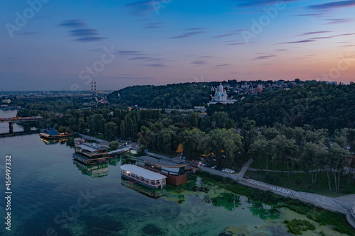 Evening Kiev from a bird's eye view. Architectural monuments. The light of lanterns and evening lights. City on the Dnieper. White buildings. Sunset.