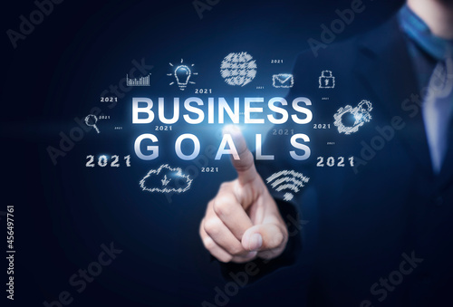 Business and Technology target set goals and achievement in 2021 new year resolution, planning and start up strategies and ideas graphic icon design concept businessman copy space blue background
