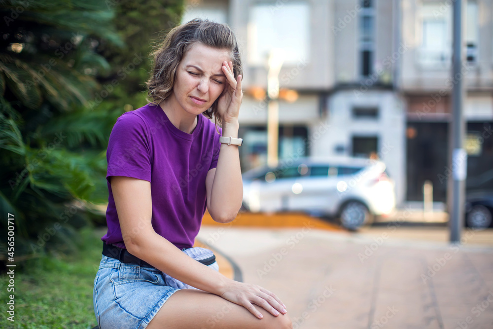 Fototapeta premium Female feeling headache on the street. Stressed woman