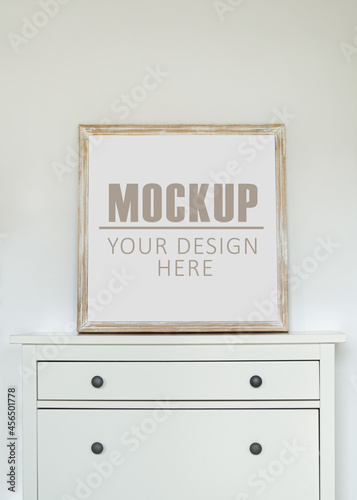 Frame, poster mock up with wooden frame. Empty frame standing on the commode. Free space for your picture or text, copy space. Minimalist design
