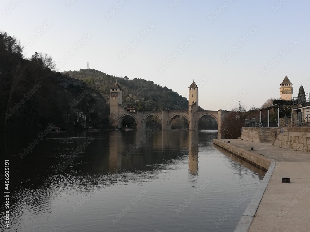 Le long des quais de Cahors, avec le pont Valentré au loin se reflétant dans l'eau