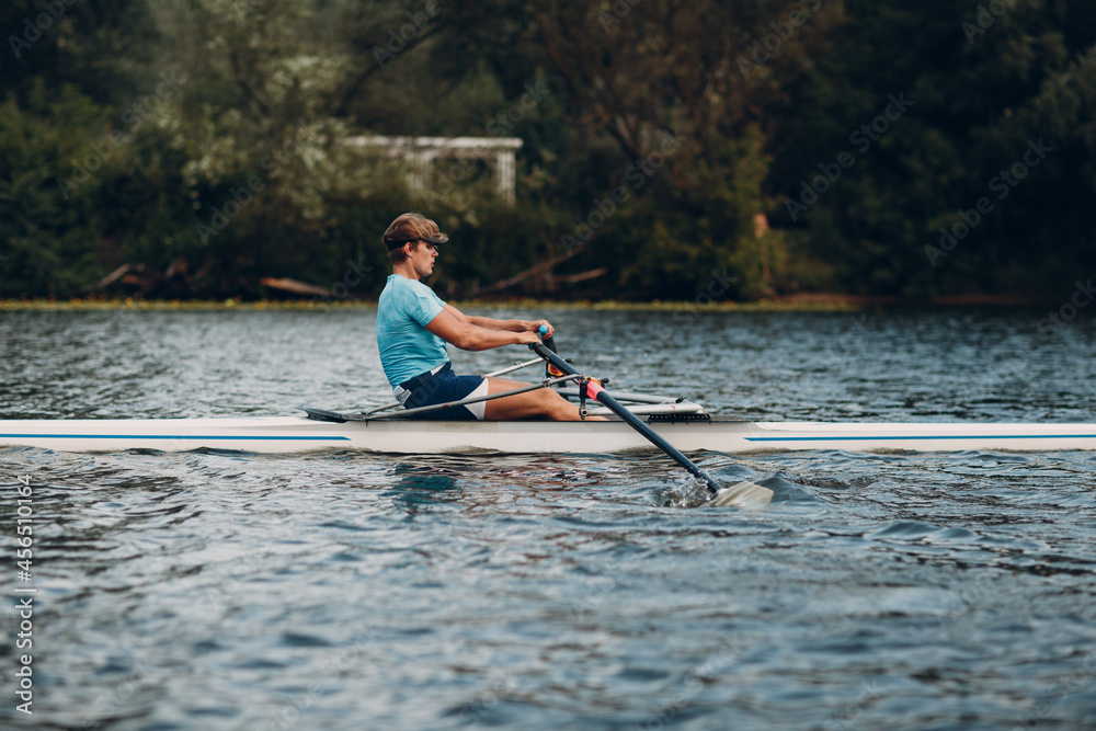Sportsman single scull man rower rowing technique on boat. Paddle oar splash movement motion Sportsman single scull man rower rowing technique on boat. Paddle oar splash movement motion