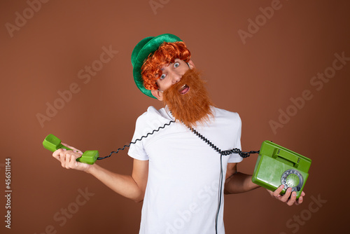 St.Patrick 's Day. Funny guy with a red beard on a brown background. photo