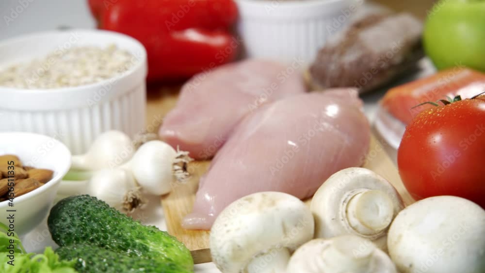 Raw chicken, mushrooms and fish on the table next to vegetables. Ingredients for making a delicious soup. Fine cuisine. Close-up. Raw chicken, mushrooms and fish on the table next to vegetables. Ingredients for making a delicious soup. Fine cuisine. Close-up.