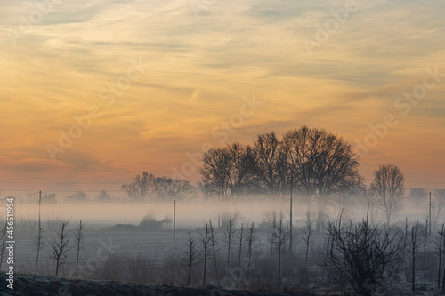 il sole e la nebbia si alzano in una fredda mattina