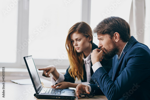managers sitting at a desk with a laptop communication technologies