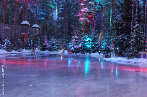 Backlit bright ice on a skating rink in the middle of the forest