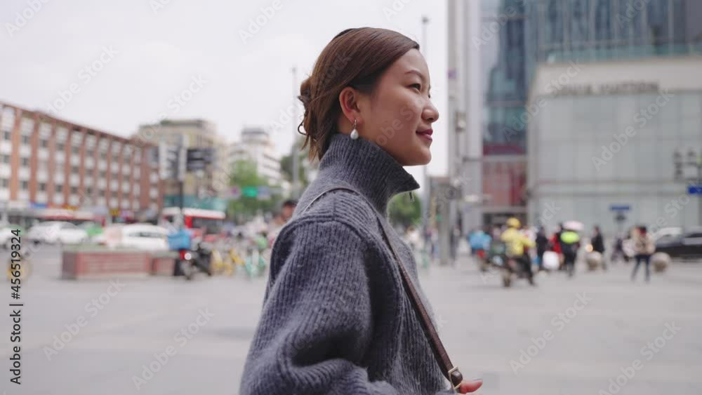 4k slow motion of Asian pretty businesswoman wears gray sweater walking in the Chengdu city. 4k slow motion of Asian pretty businesswoman wears gray sweater walking in the Chengdu city.