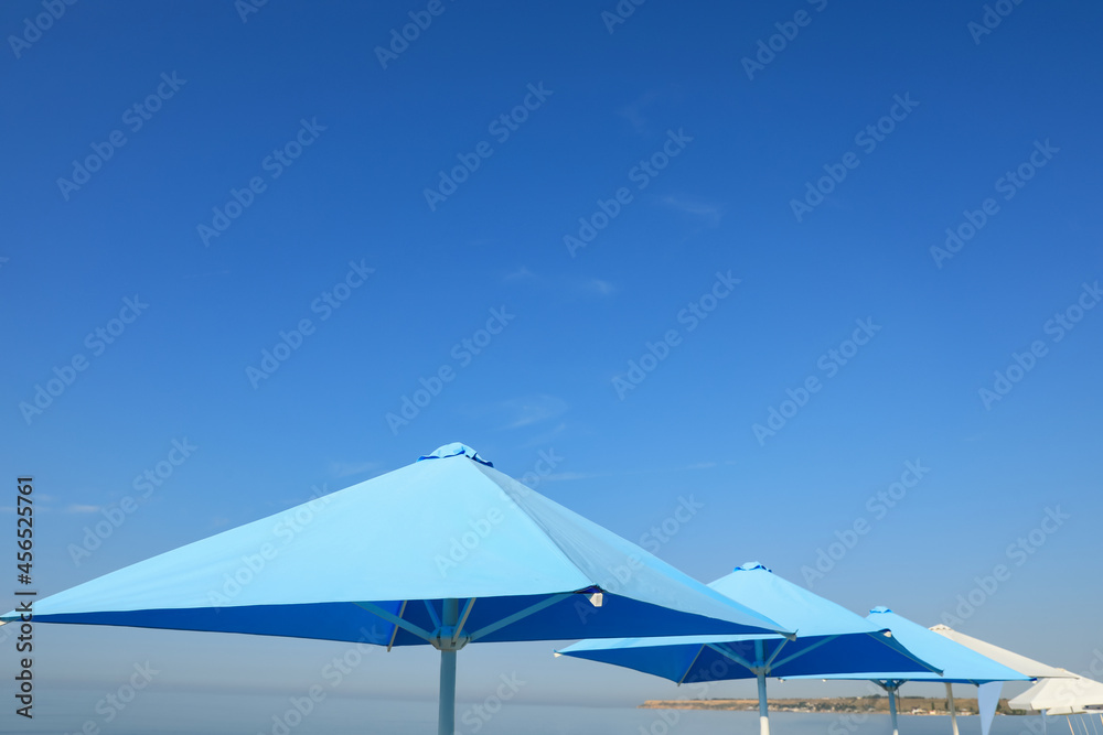 Bright beach umbrellas against blue sky on sunny day