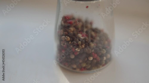 in pepperA man shows a mixture of dried peppercorns in a pepper mill.  photo