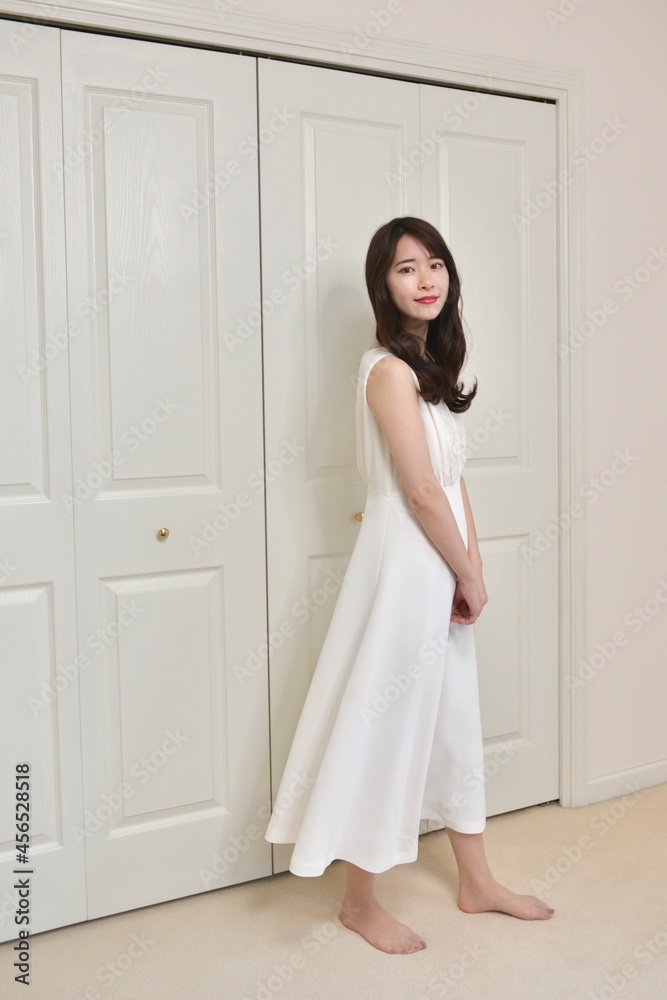 白いドレスを着た若く美しい微笑む女性の立ちポーズ 白いドレスを着た若く美しい微笑む女性の立ちポーズ