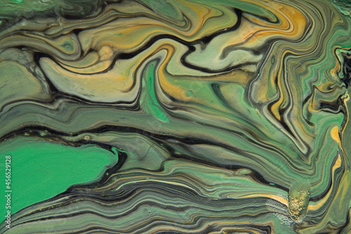 Texture in the style of fluid art. Abstract background with paint mixing effect. Liquid acrylic paint background. Black, orange and green colors.