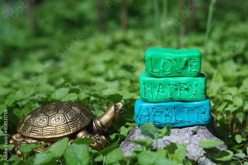 Turtle figurine close-up. Next to the inscription love, happy, health. photo