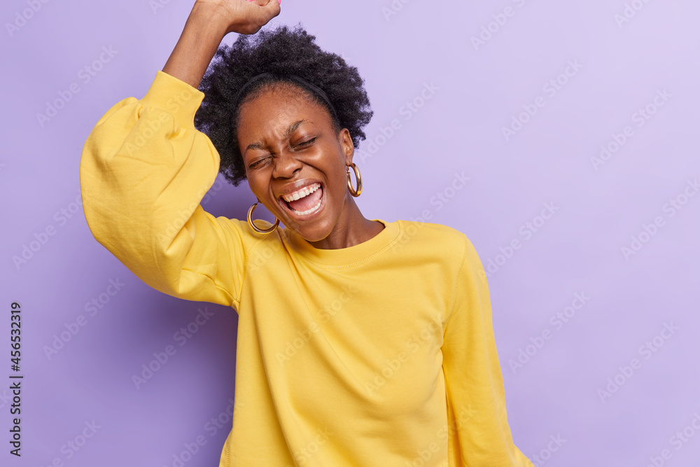 Studio shot of overjoyed curly haired 