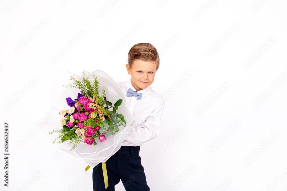 Cute boy child with a bouquet of flowers on a white isolated background Cute boy child with a bouquet of flowers on a white isolated background