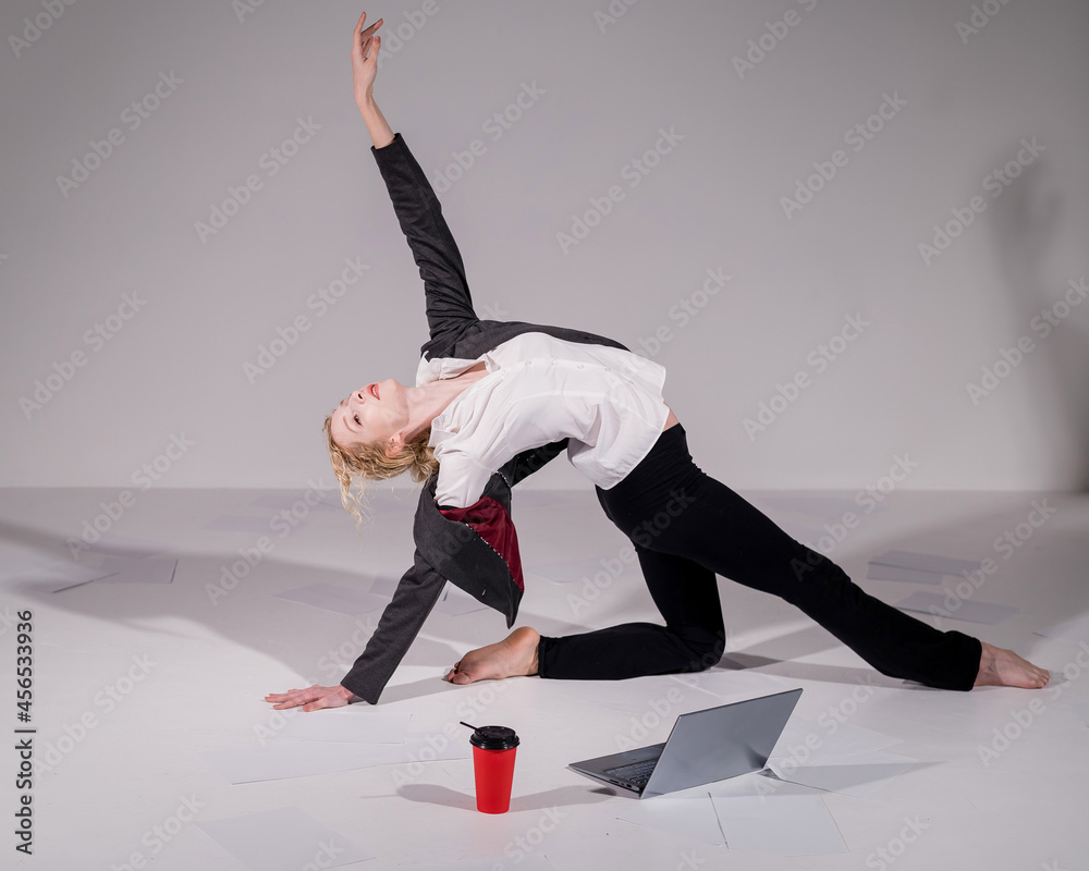 Barefoot ballerina dressed in a business suit poses for a laptop and drinks  coffee. Flexible woman works at the computer foto de Stock | Adobe Stock