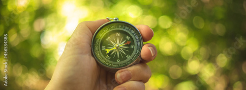 Orienteering in the woods with compass in the hand, banner photo